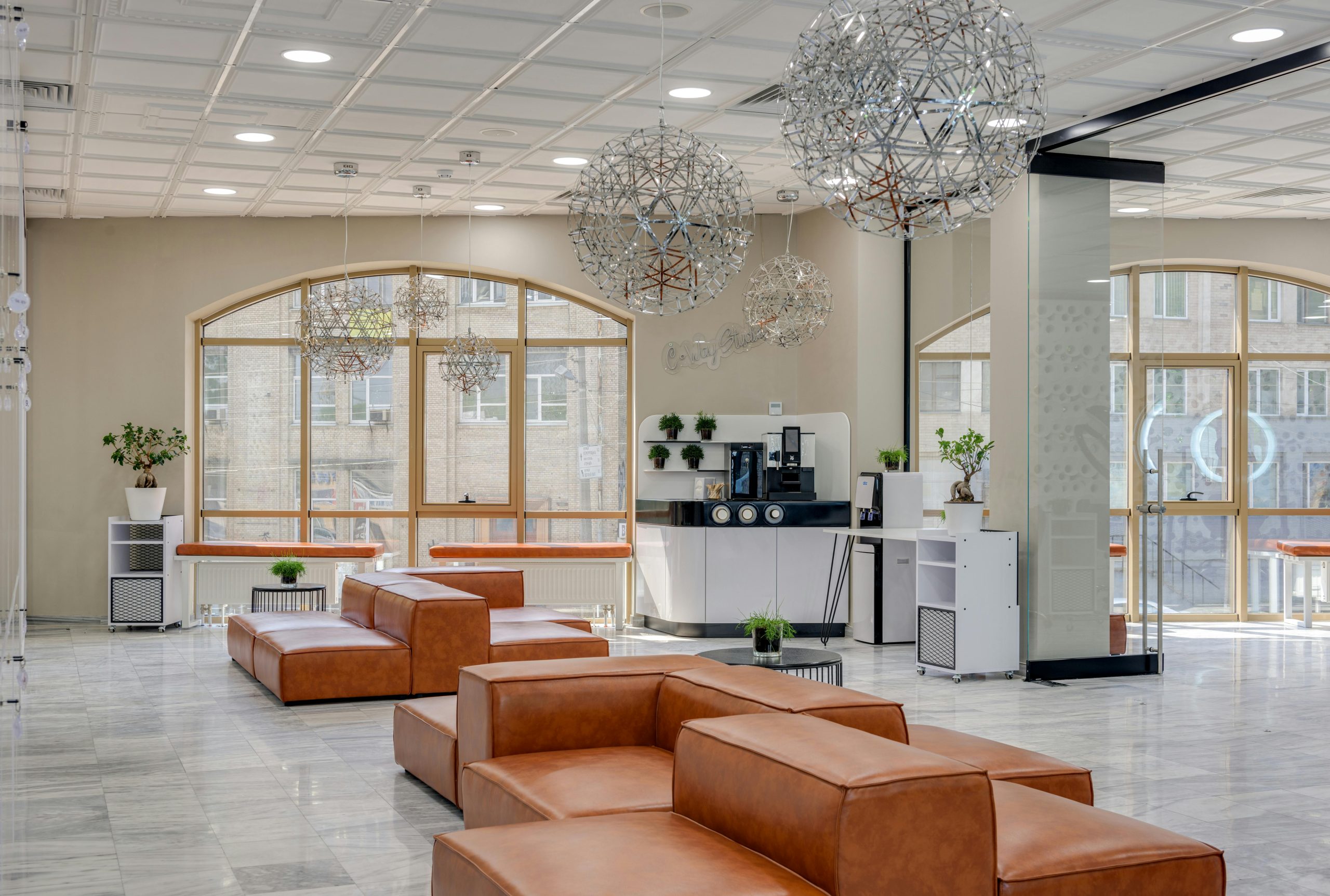 Spacious and modern lounge area with leather sofas and geometric lighting fixtures.